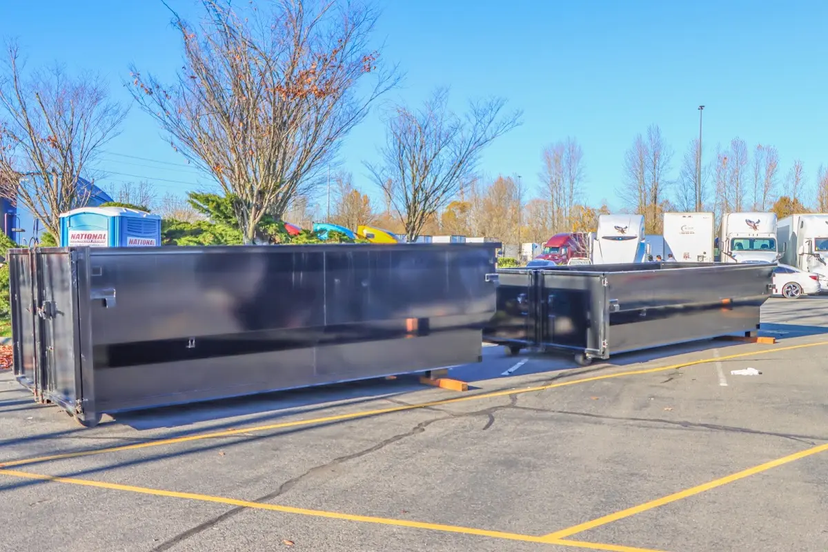 Professional dumpster rental service with roll-off container on residential driveway in Fuller Heights